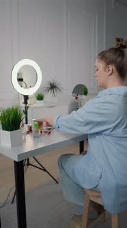 Alegre artista de maquillaje archivando un tutorial en vídeo para un blog en las redes sociales en Studio Influencer