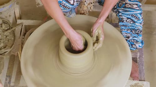 Artisan Potter Shaping Clay on a Spinning Wheel