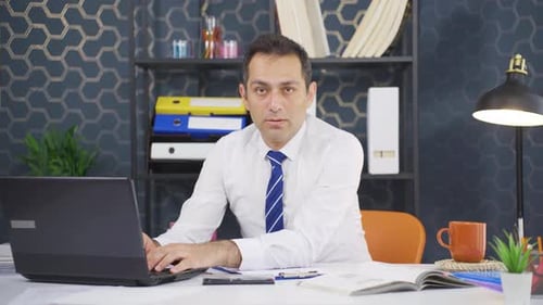 Man Works on Laptop in Office Setting