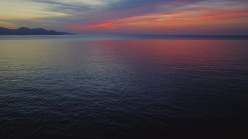 Colorful sunset sky reflecting on calm open sea during peaceful evening hour