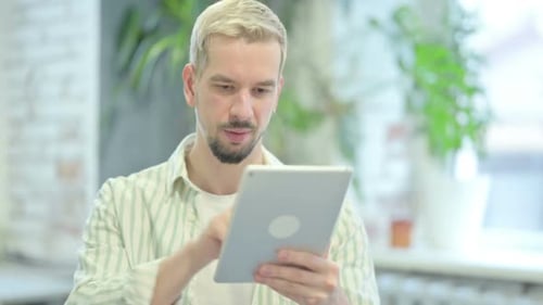 Man Using Tablet Indoors During the Daytime