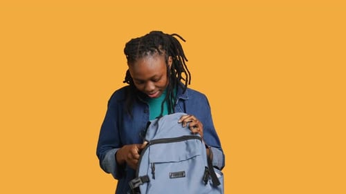 Girl Taking Out Business Class Materials Out of Rucksack Studio Background