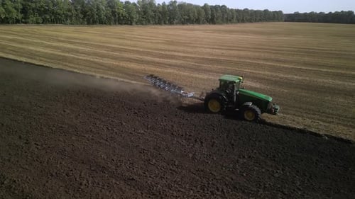 Green Tractor Plowing the Fields with Plow
