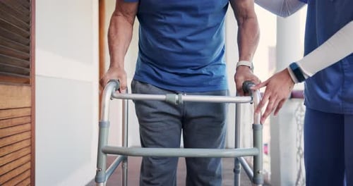 Adult Uses Walker With Medical Professional Assisting