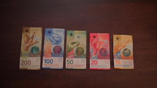 Swiss Franc Banknotes Lined Up on Wooden Table