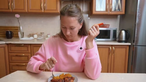 Unhappy young woman eating meal alone at home