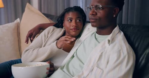 Affectionate Couple Cuddling with Popcorn Indoors