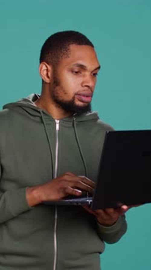 Вертикальное видео: человек печатает на клавиатуре ноутбука и проверяет электронную почту, обрадованный хорошими новостями