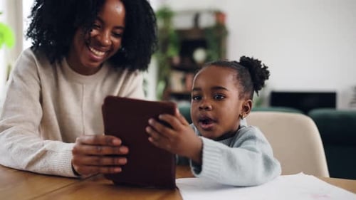 Young Black Mother and Her Daughter Using a Tablet at Home