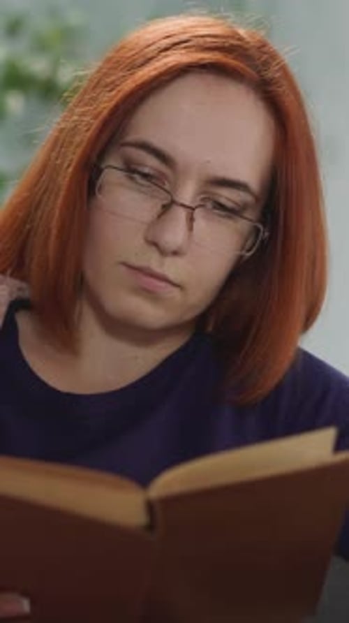 Concentrated Housewife in Glasses Reads Book Flipping Pages