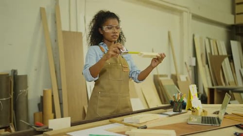 Professional carpenter or woodworker or charpentier woman use measuring tape to measure wood lenght