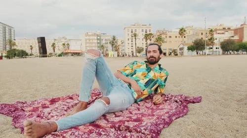Junger Mann entspannt sich am Strand