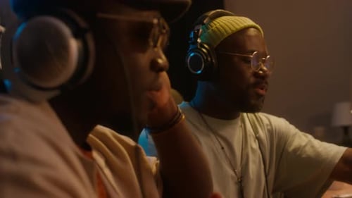 Two Black Male Producers Enjoying New Rap Song, Rocking to Rhythm in Studio