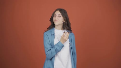 Young woman with no vision problems throws glasses in trash.