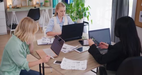 Three Female Colleagues Working on Laptops in Office