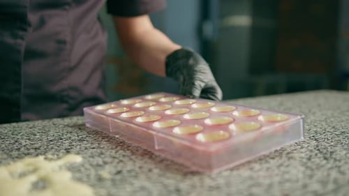 Chef Hand Filling Chocolate Mold With Filling