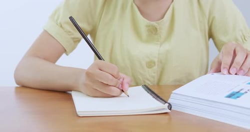 Schüler schreiben Notiz, Klassenzimmer, Bildungsumgebung, Nahaufnahme, Lernkonzept