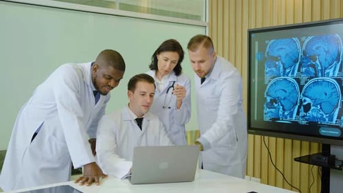 Medical Team Analyzing Brain Scans on Laptop