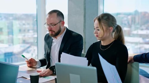 Professionals Discuss Charts and Graphs in Meeting