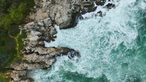 Aerial View of Waves Crashing on Rocky Coastline