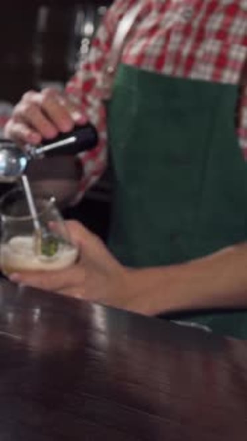 Craft Beer Glass Sparkling on the Bar As a Bartender Expertly Pours Another Drink