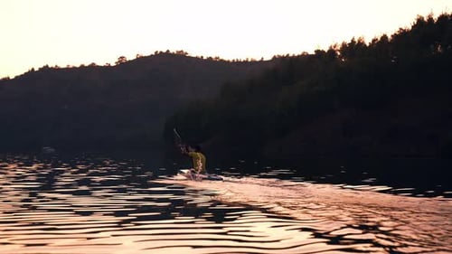 Kayaker Paddling on Calm Lake at Sunset