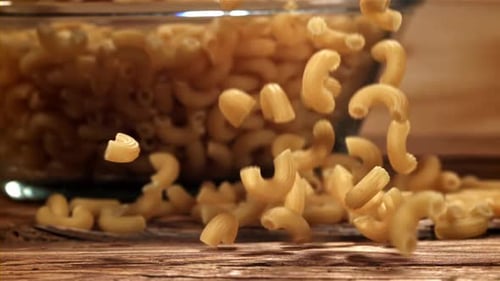 Dry Pasta Falls on a Wooden Table Filmed on a Highspeed Camera at 1000 Fps
