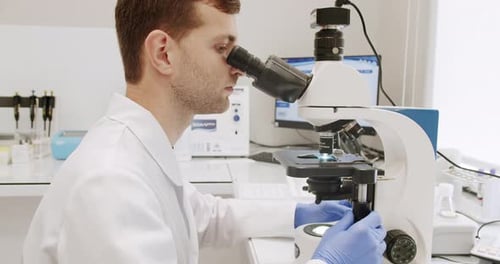 Scientist Using Microscope in Bright Lab Environment