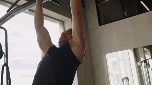 Athlet macht Klimmzüge im Fitnesscenter