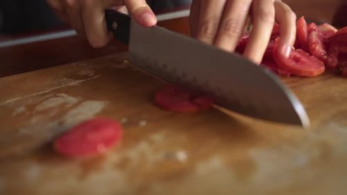 Slicing Fresh Tomatoes with Knife on Cutting Board
