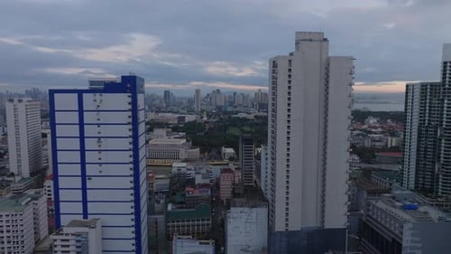 Forwards Fly Between Tall Buildings in Urban Borough Revealing River Park and Cityscape with Modern