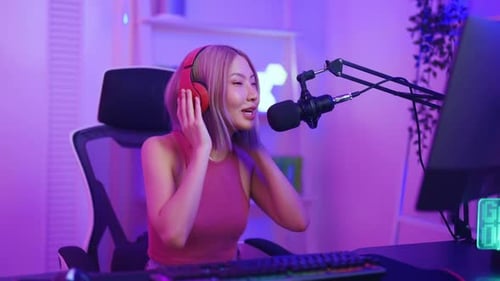 Asian young audio DJ woman sing a song on microphone to broadcasting.
