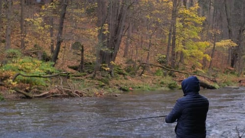 Man Fishing in a River During Autumn