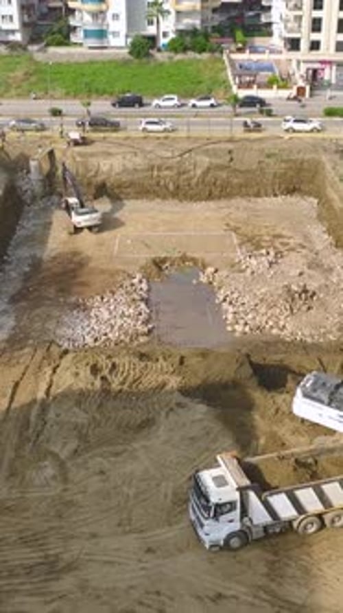 Vídeo vertical: trabajadores e ingenieros de la construcción que utilizan equipo pesado en un sitio activo