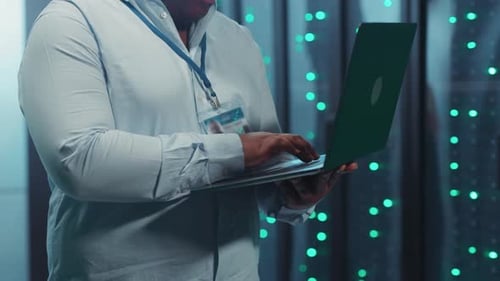 Man Working on Laptop in Data Center Server Room