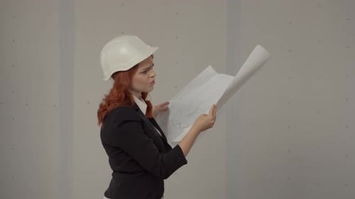 Side View of an Architect Woman Holding a Plan Drawing of a Building in Her Hands A Business Woman