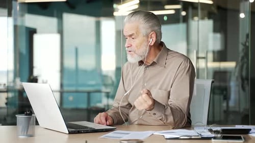 Mature Man Video Conferencing with Laptop in Modern Office