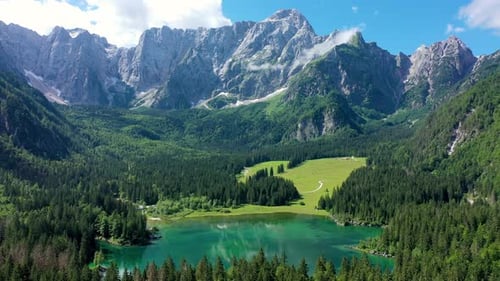 Picturesque lake Lago Fusine in Italy. Fusine lake with Mangart peak on background. Popular travel d