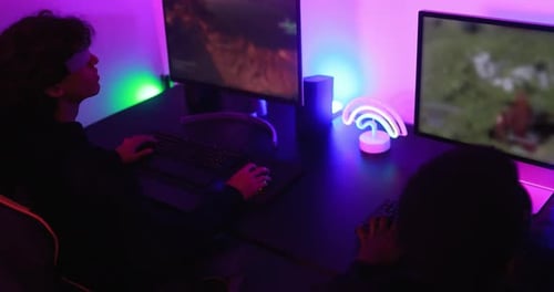 Young Adults Gaming Together in Neon Lit Room