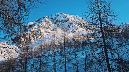 View of a snowy mountain with nets below from a moving ski tow in the Alps