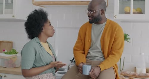 Couple Conversing in a Bright Kitchen