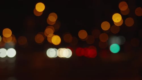 Rainy night city lights bokeh twilight. Cars drive night roads town defocus. City life, car light