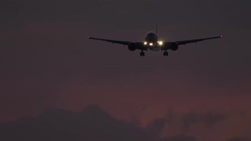 Airplane Flies in the Night Sky Headlights