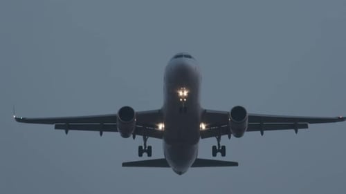 Airplane Flying at Night Landing with Landing Gear Down