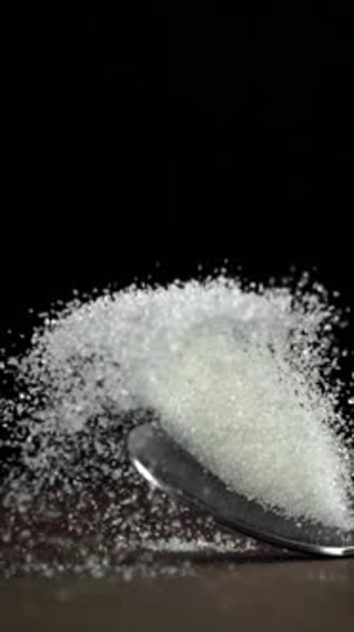 A Spoonful of Sugar Falls on the Table Filmed on a Highspeed Camera at 1000 Fps