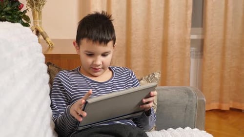 Boy Interacting with Tablet Device at Home