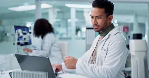 Scientist Uses Laptop in Modern Laboratory