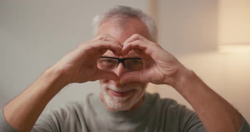 Senior Man Gesturing Love to Camera