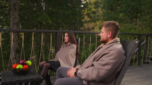 Gentleman and Lady Relax on Terrace at Dusk