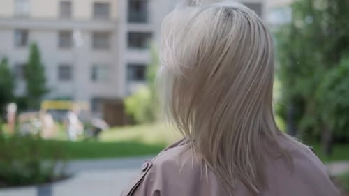 Blonde Woman Walking Outside Turns To Face Camera